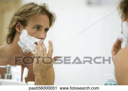 Man looking in mirror, applying shaving cream View Large Photo Image Stock Image - Man looking in mirror, applying shaving cream. Fotosearch