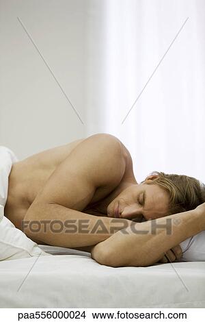 Man lying on side in bed sleeping View Large Photo Image Picture - Man lying on side in bed sleeping. Fotosearch
