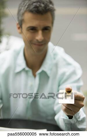Stock Photography - Man offering credit card for payment. Fotosearch
