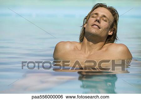 Stock Photograph - Man relaxing in shallow end of pool. Fotosearch