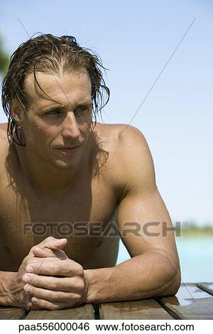 Man resting at edge of pool, leaning on elbow looking away View Large Photo Image Stock Photograph - Man resting at edge of pool, leaning on elbow looking away. Fotosearch