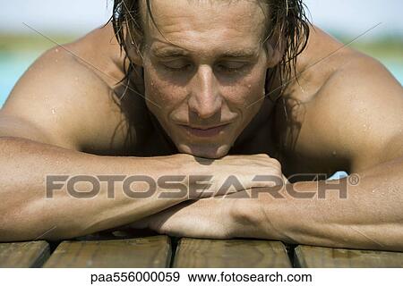 Muscular swimmer resting at edge of pool resting head on arms, eyes closed View Large Photo Image Stock Photo - Muscular swimmer resting at edge of pool resting head on arms, eyes closed. Fotosearch