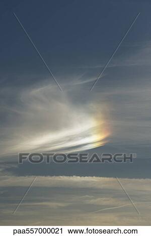 Stock Image - Cloudscape with partial rainbow. Fotosearch