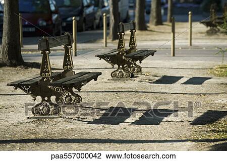 Ornate park benches casting shadows on ground View Large Photo Image Stock Image - Ornate park benches casting shadows on ground. Fotosearch