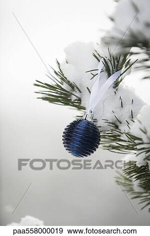 Christmas ornament hanging from snow-covered branch View Large Photo Image Stock Photo - Christmas ornament hanging from snow-covered branch. Fotosearch