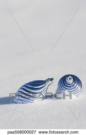 Stock Photo - Christmas ornaments on snow-covered ground. Fotosearch