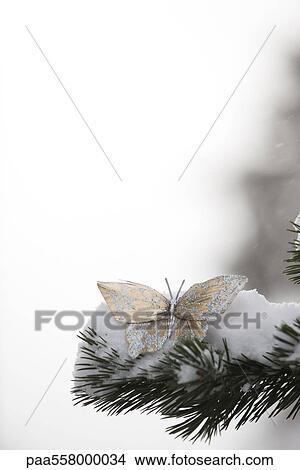 Golden decorative butterfly on snow-covered branch View Large Photo Image Picture - Golden decorative butterfly on snow-covered branch. Fotosearch