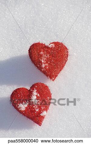 Heart shaped ornaments on snow View Large Photo Image Stock Image - Heart shaped ornaments on snow. Fotosearch