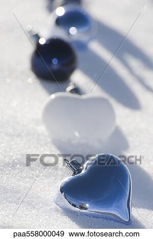 Heart shaped ornaments placed in row on snow View Large Photo Image Stock Photo - Heart shaped ornaments placed in row on snow. Fotosearch
