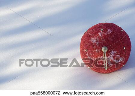 Red Christmas ornament lying on snow View Large Photo Image Stock Image - Red Christmas ornament lying on snow. Fotosearch