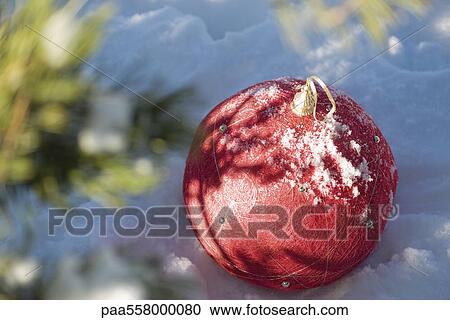 Red Christmas ornament on snowy ground View Large Photo Image Stock Image - Red Christmas ornament on snowy ground. Fotosearch