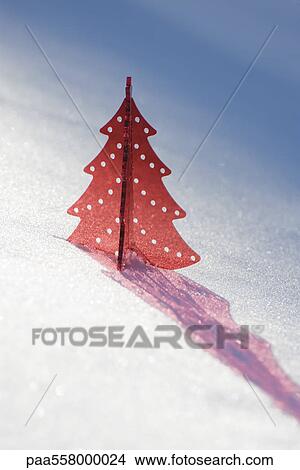 Red plastic Christmas tree decoration set in snow casting shadow View Large Photo Image Picture - Red plastic Christmas tree decoration set in snow casting shadow. Fotosearch