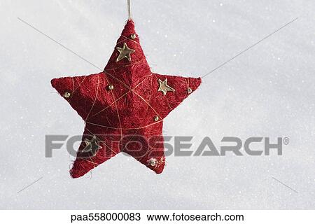Star Christmas ornament hanging against snowy background View Large Photo Image Stock Image - Star Christmas ornament hanging against snowy background. Fotosearch
