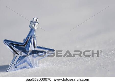 Stock Image - Star Christmas ornament in snow. Fotosearch