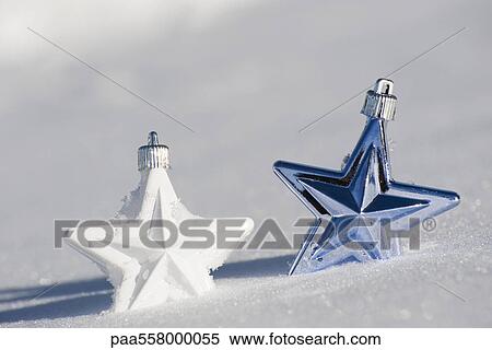 Stock Photography - Star Christmas ornaments in snow. Fotosearch