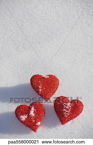 Three heart shaped ornaments on snow View Large Photo Image Stock Image - Three heart shaped ornaments on snow. Fotosearch