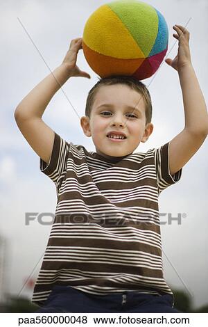 Boy balancing ball on head View Large Photo Image Stock Photo - Boy balancing ball on head. Fotosearch