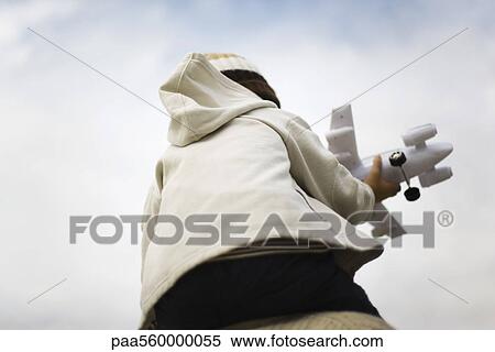 Boy sitting on parent's shoulders, holding toy airplane, rear view View Large Photo Image Stock Photography - Boy sitting on parent's shoulders, holding toy airplane, rear view. Fotosearch