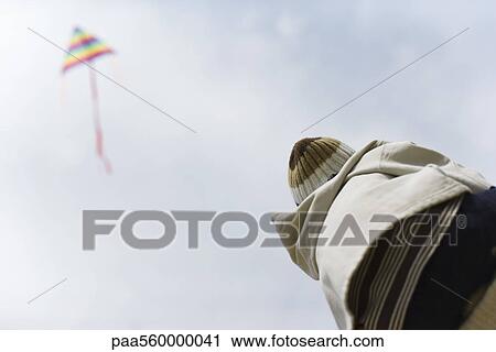 Child watching kite in sky, rear view View Large Photo Image Stock Image - Child watching kite in sky, rear view. Fotosearch