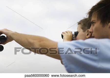 Father and son looking through binoculars, side view View Large Photo Image Stock Image - Father and son looking through binoculars, side view. Fotosearch