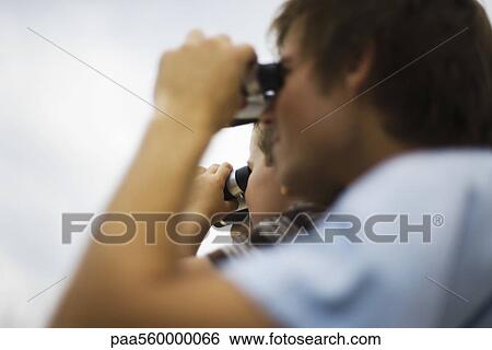 Father and son looking through binoculars, side view View Large Photo Image Stock Photograph - Father and son looking through binoculars, side view. Fotosearch