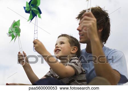 Father and young son holding pinwheels View Large Photo Image Stock Image - Father and young son holding pinwheels. Fotosearch