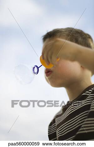 Little boy blowing bubble with bubble wand, low angle view View Large Photo Image Stock Photo - Little boy blowing bubble with bubble wand, low angle view. Fotosearch