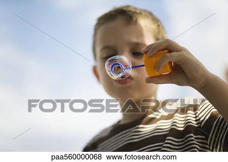 Little boy blowing bubble with bubble wand View Large Photo Image Stock Photo - Little boy blowing bubble with bubble wand. Fotosearch