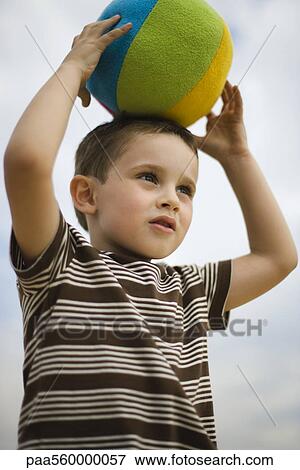 Little boy holding ball on top of head View Large Photo Image Stock Photo - Little boy holding ball on top of head. Fotosearch