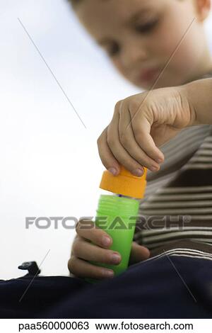 Little boy opening bottle of bubbles, low angle view View Large Photo Image Stock Image - Little boy opening bottle of bubbles, low angle view. Fotosearch