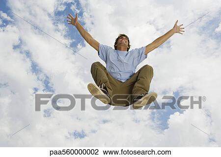 Young man jumping in midair, low angle view View Large Photo Image Stock Image - Young man jumping in midair, low angle view. Fotosearch