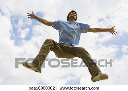 Young man jumping in midair, low angle view View Large Photo Image Stock Image - Young man jumping in midair, low angle view. Fotosearch
