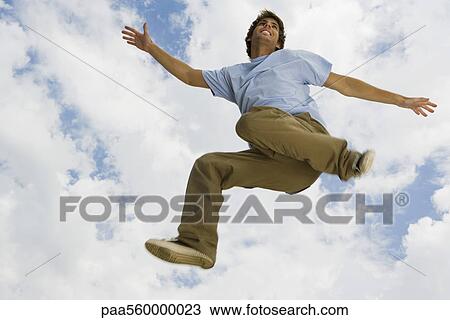 Young man jumping in midair, low angle view View Large Photo Image Stock Image - Young man jumping in midair, low angle view. Fotosearch