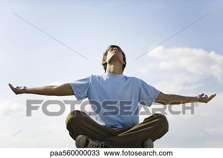 Young man meditating outdoors, holding yin yang balls in each hand View Large Photo Image Stock Image - Young man meditating outdoors, holding yin yang balls in each hand. Fotosearch