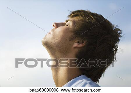 Young man outdoors with head back, eyes closed View Large Photo Image Stock Photo - Young man outdoors with head back, eyes closed. Fotosearch