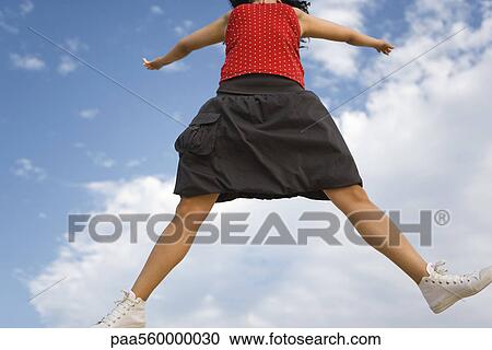 Young woman jumping in midair, cropped View Large Photo Image Stock Image - Young woman jumping in midair, cropped. Fotosearch