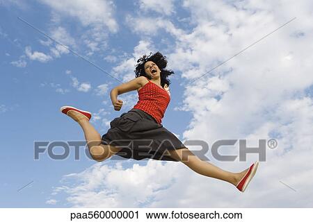 Young woman jumping in midair, low angle view View Large Photo Image Stock Image - Young woman jumping in midair, low angle view. Fotosearch