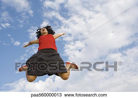 Young woman jumping in midair, low angle view View Large Photo Image Stock Image - Young woman jumping in midair, low angle view. Fotosearch