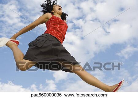 Young woman jumping in midair, low angle view View Large Photo Image Stock Photograph - Young woman jumping in midair, low angle view. Fotosearch