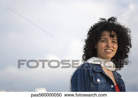 Young woman smiling outdoors, portrait View Large Photo Image Stock Image - Young woman smiling outdoors, portrait. Fotosearch