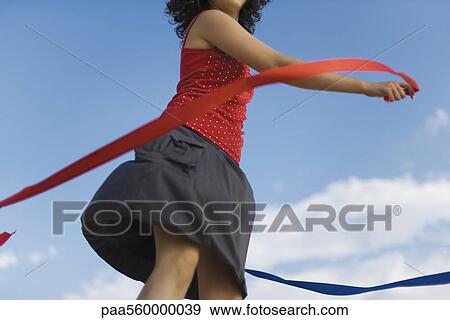 Young woman spinning around with ribbons outdoors View Large Photo Image Stock Photo - Young woman spinning around with ribbons outdoors. Fotosearch