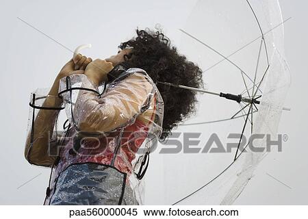 Young woman with raincoat and umbrella standing in rain View Large Photo Image Stock Photography - Young woman with raincoat and umbrella standing in rain. Fotosearch