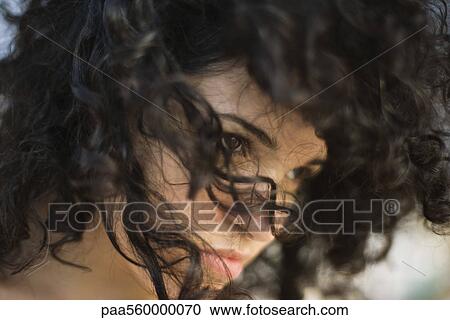Young woman with tousled hair looking away, close-up View Large Photo Image Stock Image - Young woman with tousled hair looking away, close-up. Fotosearch