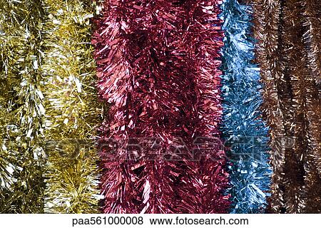 Stock Photo - Metallic Christmas garlands, close-up. Fotosearch
