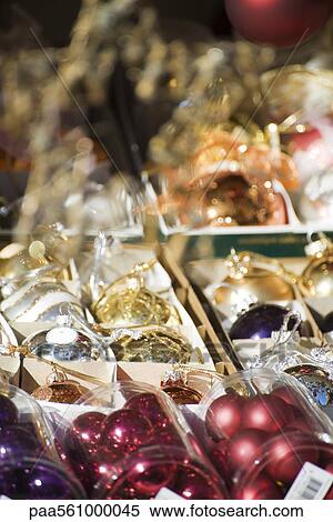 Stock Photography - Packs of Christmas ornaments on display in shop, close-up. Fotosearch