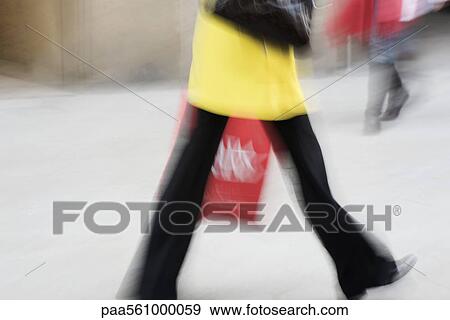 Stock Photo - Pedestrian carrying shopping bag, cropped. Fotosearch