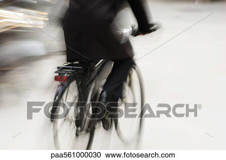 Stock Image - Person riding bicycle, blurred. Fotosearch