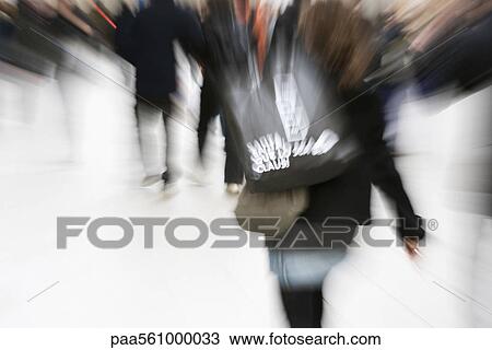 Stock Image - Shopper carrying shopping bag, blurred. Fotosearch