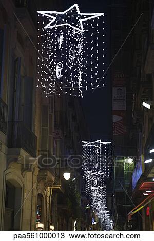 Star-shaped lights hanging along city street at night View Large Photo Image Stock Image - Star-shaped lights hanging along city street at night. Fotosearch