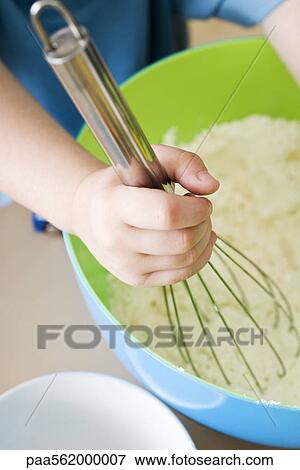 Stock Photo - Child stirring batter with whisk, cropped view. Fotosearch